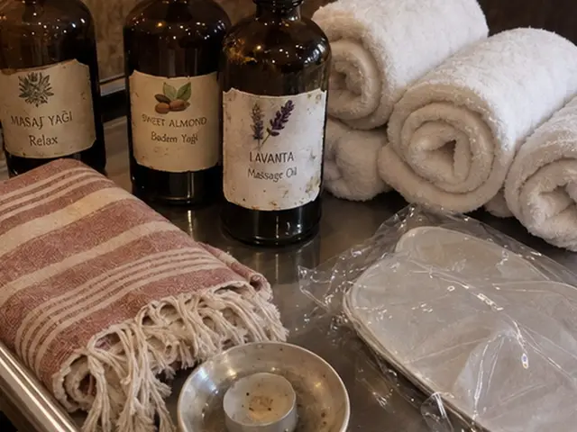 Masaj yağı şişeleri, rulo havlular ve pembe peştemal — Feriköy, Masaj Salonun